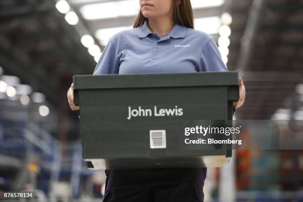 John Lewis Plc partner carries a tote box in the John Lewis Plc customer fulfilment and distribution centre in Milton Keynes, U.K., on Friday, Nov....