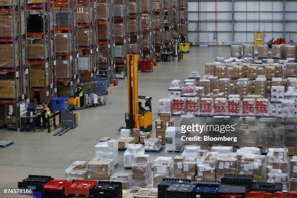 Forklift truck driver manoeuvres among aisles of goods at the John Lewis Plc customer fulfilment and distribution centre in Milton Keynes, U.K., on...