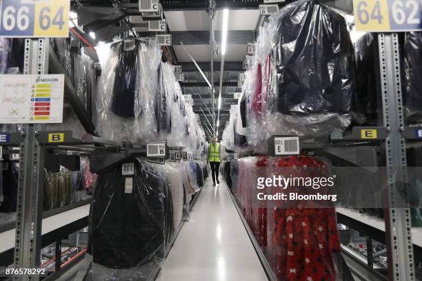 John Lewis Plc partner walks through the hanging garment automated warehouse at the John Lewis Plc customer fulfilment and distribution centre in...