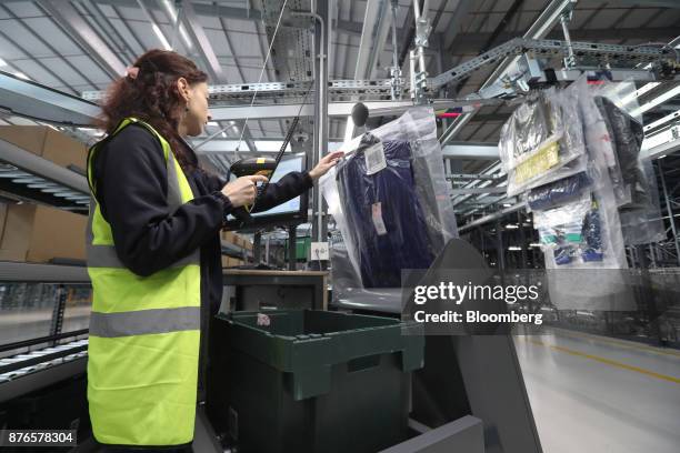 John Lewis Plc partner scans and packs hanging garments at the John Lewis Plc customer fulfilment and distribution centre in Milton Keynes, U.K., on...