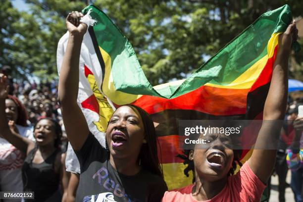 Women holding a flag of Zimbabwe take part in a demonstration of University of Zimbabwe's students, on November 20, 2017 in Harare, to demand the...