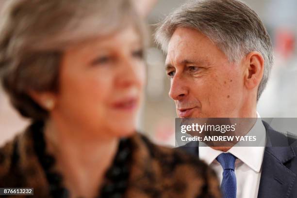 Britain's Prime Minister Theresa May and Britain's Chancellor of the Exchequer Philip Hammond react during a visit an engineering training facility...