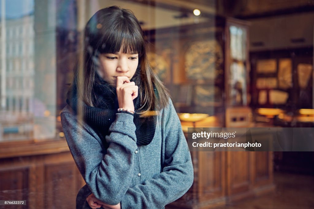 Serious teenage girl is looking museum exhibition with interest