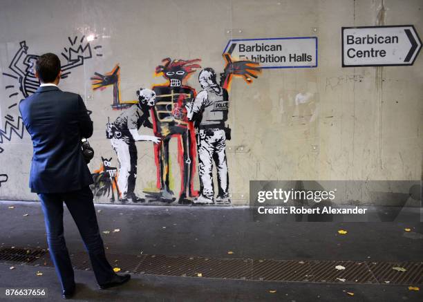 Man stops to admire street art created in September 2017 near the Barbican Centre in London, England, by Banksy, an anonymous England-based graffiti...