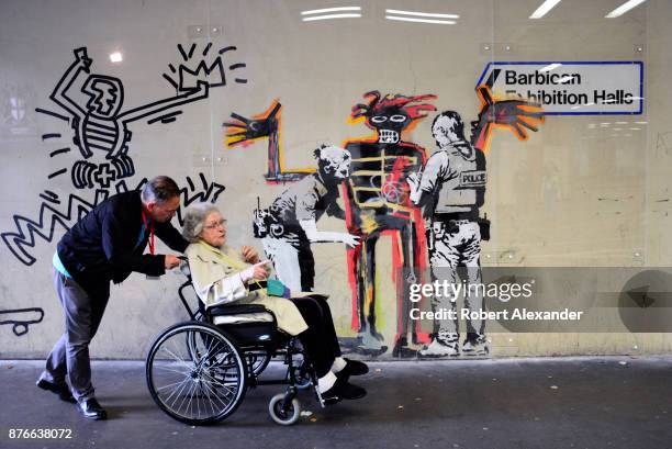 Londoners admire street art created in September 2017 near the Barbican Centre in London, England, by Banksy, an anonymous England-based graffiti...