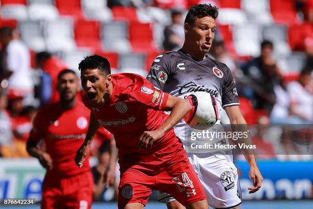 Pablo Barrientos of Toluca struggles for the ball with Damian Musto of Tijuana during the 17th round match between Toluca and Tijuana as part of the...