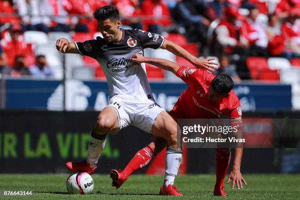 Henry Martin of Tijuana struggles for the ball with Rubens Sambueza of Toluca during the 17th round match between Toluca and Tijuana as part of the...