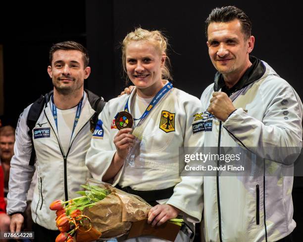 Germany's u78kg bronze medallist, Luise Malzahn, happily shows her medal alongside her coaches, Claudiu Pusa and Costel Dorin Danculea during the The...