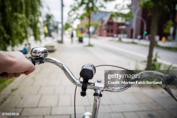 close up of a man's hand holding a bicycle handlebar in hafen city, germany in spring - handlebar stock pictures, royalty-free photos & images