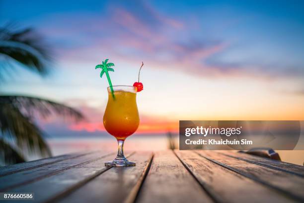 cocktail during sunset at beach - orange cocktail beach stock pictures, royalty-free photos & images