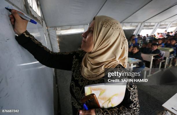 Displaced Iraqi children from the former embattled city of Mosul attend class at a United Nations Children's Fund school at the Hasan Sham camp, some...