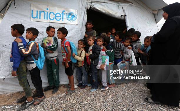 Displaced Iraqi children from the former embattled city of Mosul queue up outside a United Nations Children's Fund school at the Hasan Sham camp,...