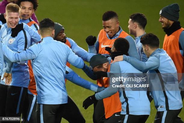 Manchester City's Portuguese midfielder Bernardo Silva reacts as he is mobbed by teammates, including Manchester City's Belgian midfielder Kevin De...