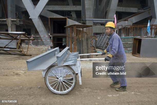 China, Hebei, Beijing - Sommerolympiade 2008, Blick auf die Baustelle des Nationalstadions, Bauarbeiter transportiert Stahlbauteile auf dem...