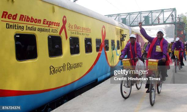 Activists of Nehru Yuva Kendra rides on their bicycles as the Red Ribbon Express train leaves the platform at Safdarjung Railway Station in New...