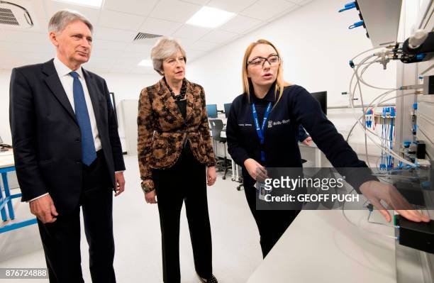 Britain's Chancellor of the Exchequer Philip Hammond and Britain's Prime Minister Theresa May visit an engineering training facility in the...