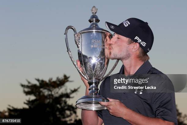 Austin Cook of United States celebrates with the trophy on the 18th green after winning the final round of The RSM Classic at Sea Island Golf Club...