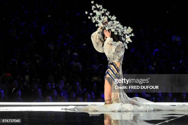 Chinese model Ming Xi falls as she presents a creation during the 2017 Victoria's Secret Fashion Show in Shanghai on November 20, 2017. / AFP PHOTO /...