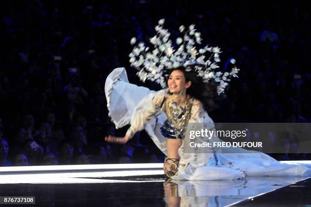 Chinese model Ming Xi falls as she presents a creation during the 2017 Victoria's Secret Fashion Show in Shanghai on November 20, 2017. / AFP PHOTO /...