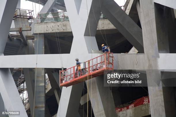 China, Hebei, Beijing - Sommerolympiade 2008, Blick auf die Baustelle des Nationalstadions, Bauarbeiter an der Stahlkonstruktion | Summer Olympics...