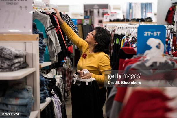 An employee restocks children's clothes on dispaly for sale at a J.C. Penney Co. Store in the Queens borough of New York, U.S., on Monday, Nov. 20,...