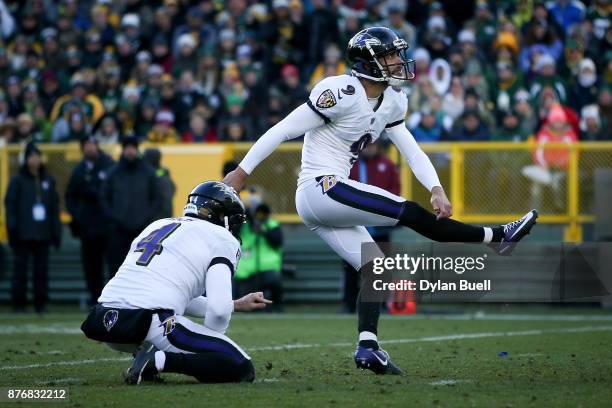 Justin Tucker of the Baltimore Ravens kicks a field goal as Sam Koch holds in the fourth quarter against the Green Bay Packers at Lambeau Field on...