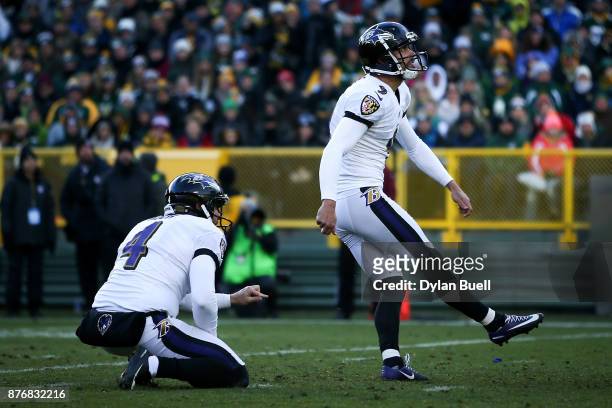 Justin Tucker of the Baltimore Ravens kicks a field goal as Sam Koch holds in the fourth quarter against the Green Bay Packers at Lambeau Field on...