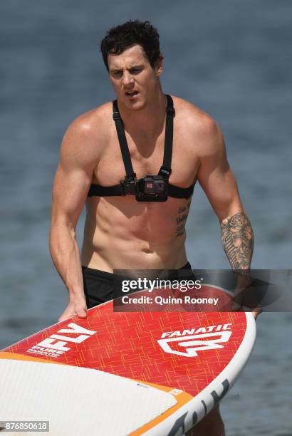 Jake Carlisle of the Saints pulls his board off the beach after doing stand up paddleboarding during a St Kilda Saints AFL training session at Catani...