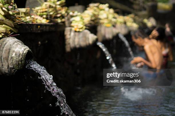 pilgrim and hindu people come to holy dip at the tirta empul temple on april 10, 2017 in bali, indonesia. - tirta empul temple stock pictures, royalty-free photos & images