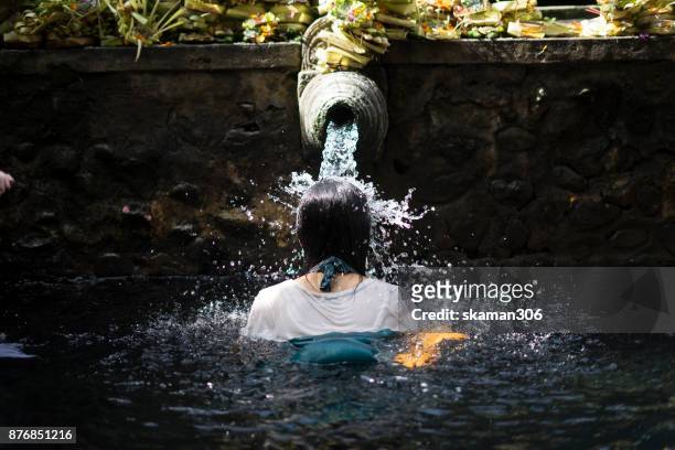 pilgrim and hindu people come to holy dip at the tirta empul temple on april 10, 2017 in bali, indonesia. - tirta empul temple stock pictures, royalty-free photos & images