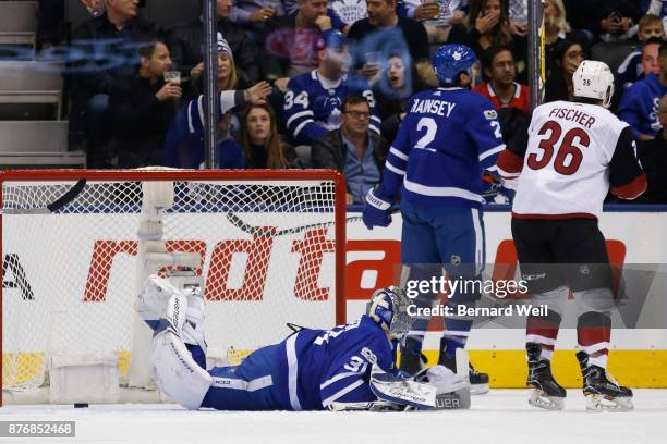 Toronto Maple Leafs defenseman Ron Hainsey and Arizona Coyotes right wing Christian Fischer skate past Toronto Maple Leafs goalie Frederik Andersen...