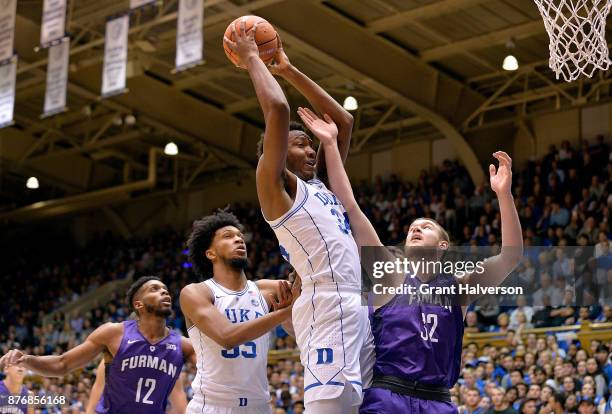 Wendell Carter Jr of the Duke Blue Devils battles Matt Rafferty of the Furman Paladins for a rebound during their game at Cameron Indoor Stadium on...