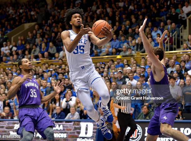 Marvin Bagley III of the Duke Blue Devils drives between Daniel Fowler and Clay Mounce of the Furman Paladins during their game at Cameron Indoor...