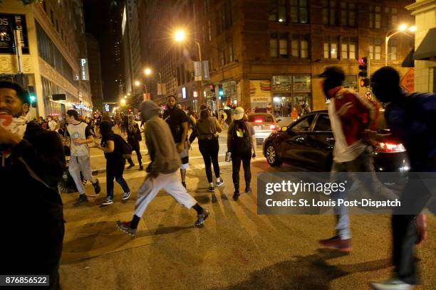 Protesters run after violence broke out on downtown streets in University City, Mo., on September 17 in the third day of protests following the not...