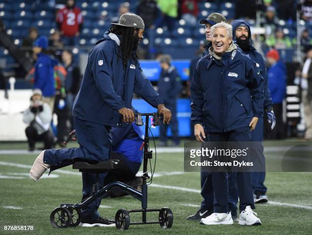 Cornerback Richard Sherman of the Seattle Seahawks, out for the season with an Achilles injury, talks with Head coach Pete Carroll before the game at...