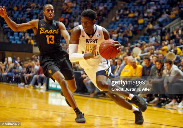 Lamont West of the West Virginia Mountaineers drives against Barry Ogalue of the Long Beach State 49ers at the WVU Coliseum on November 20, 2017 in...