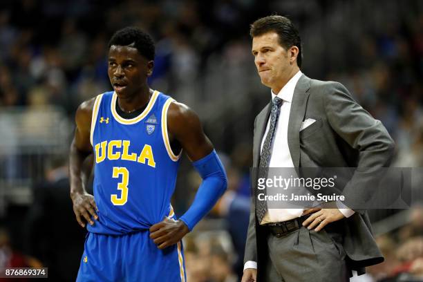 Aaron Holiday of the UCLA Bruins talks with head coach Steve Alford during the National Collegiate Basketball Hall Of Fame Classic game against the...