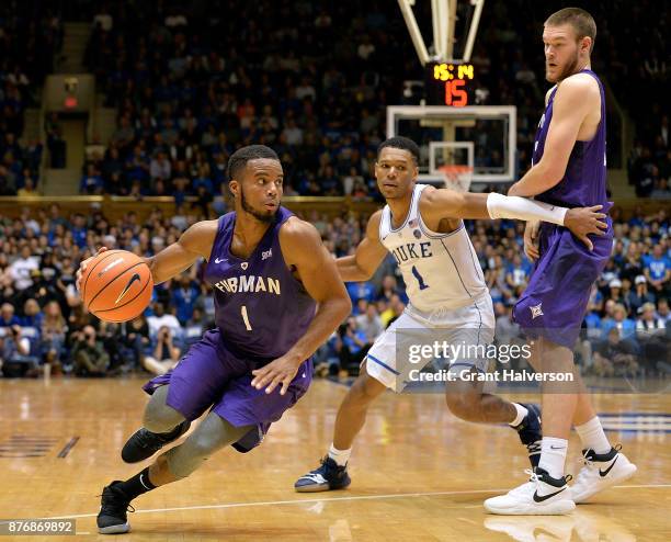 John Davis III of the Furman Paladins drives around Trevon Duval of the Duke Blue Devils during their game at Cameron Indoor Stadium on November 20,...