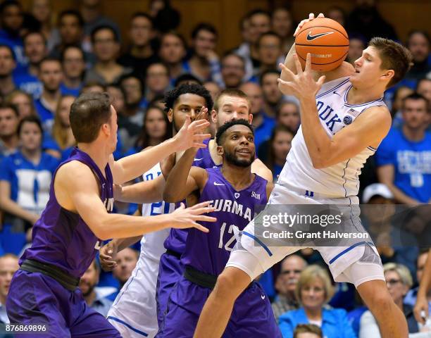 Grayson Allen of the Duke Blue Devils bobbles the ball as he pulls up against Andrew Brown and Devin Sibley of the Furman Paladins during their game...