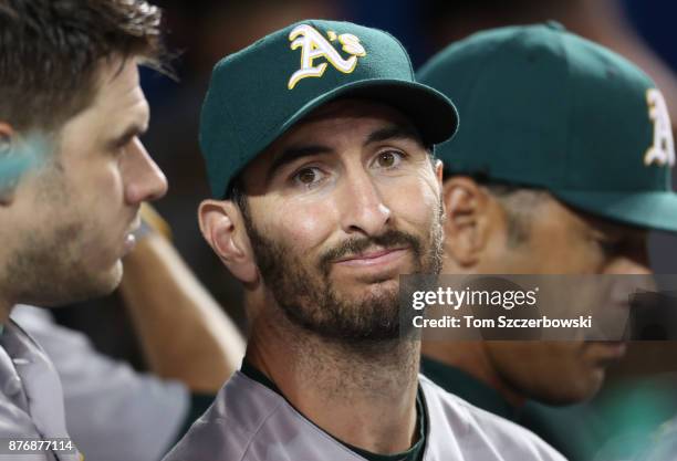 Adam Rosales of the Oakland Athletics talks to Josh Phegley in the dugout during MLB game action against the Toronto Blue Jays at Rogers Centre on...