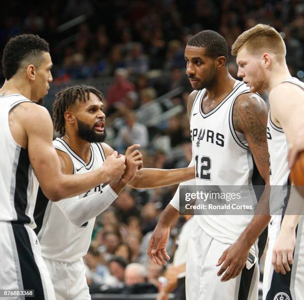 Patty Mills of the San Antonio Spurs talks with teammates Danny Green, LaMarcus Aldridge and Davis Bertans before a foul shot during the game against...