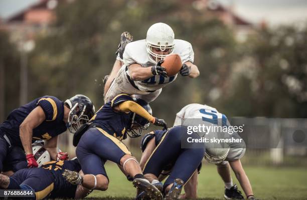 determined american football player with a ball trying to score touchdown. - first down american football stock pictures, royalty-free photos & images