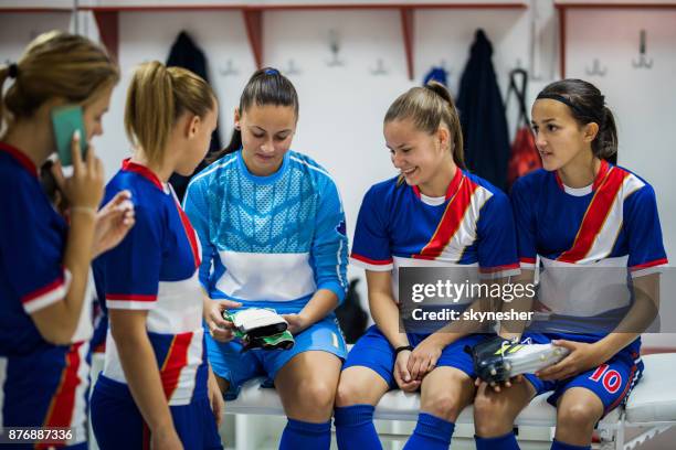 team of happy female soccer players relaxing in a locker room. - locker room stock pictures, royalty-free photos & images