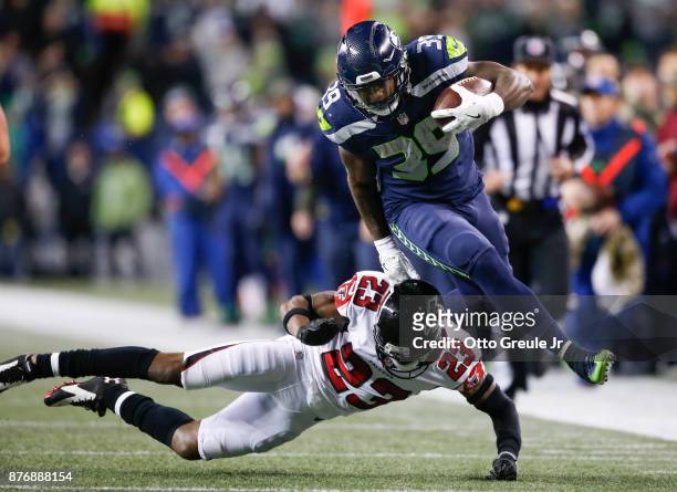 Running back Mike Davis of the Seattle Seahawks jumps over cornerback Robert Alford of the Atlanta Falcons as he rushes in the second quarter during...