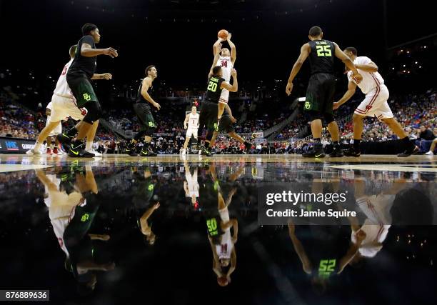 Brad Davison of the Wisconsin Badgers shoots over Manu Lecomte of the Baylor Bears during the game National Collegiate Basketball Hall Of Fame...