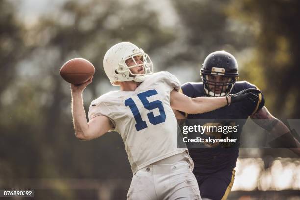 quarterback del football americano che lancia la palla durante la partita. - lancio foto e immagini stock
