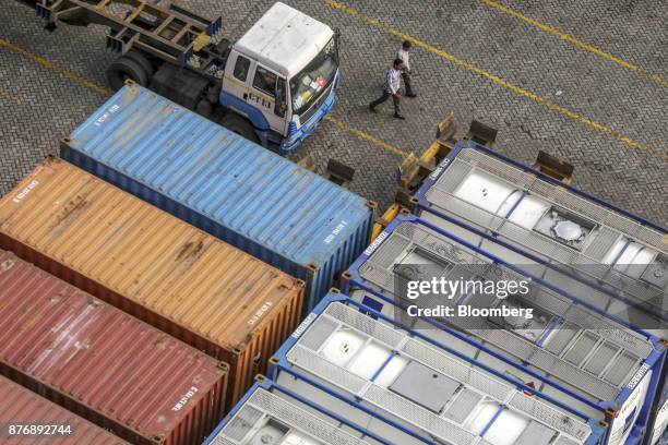 Truck sits parked next to containers stacked in a yard at Krishnapatnam Port in Krishnapatnam, Andhra Pradesh, India, on Saturday, Aug. 12, 2017....