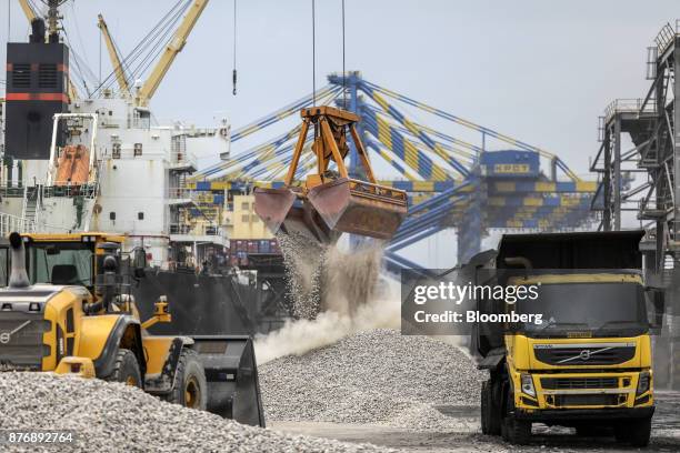 Cranes unload limestone on to the dockside from a ship, not pictured, at Krishnapatnam Port in Krishnapatnam, Andhra Pradesh, India, on Monday, Aug....