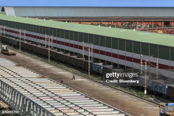 Workers walk past freight cars at Krishnapatnam Port in Krishnapatnam, Andhra Pradesh, India, on Monday, Aug. 11, 2017. Growth in gross domestic...