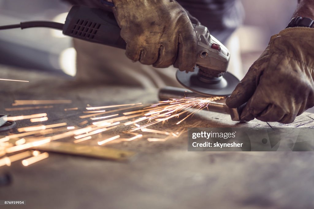 Plancha de corte obrero irreconocible con una sierra en un taller.